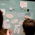 Children writing on post it notes on disaply board
