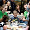 children and researchers around a table with craft items and paper