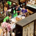 Aerial view of a table and museum cabinets with researchers and children looking at objects