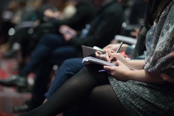 An event with people sitting down writing notes