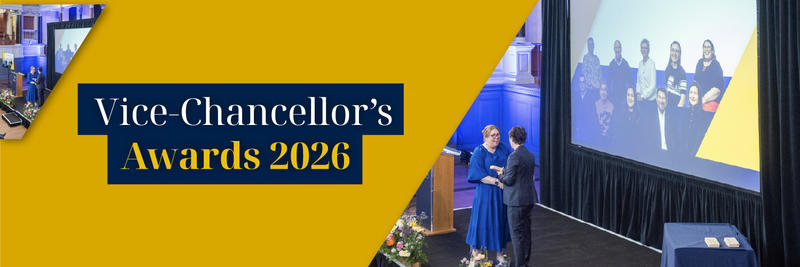 Vice-Chancellors Awards 2026. A prizewinner in a bright blue dress accepts and award from the Vice-Chancellor on a raised stage.