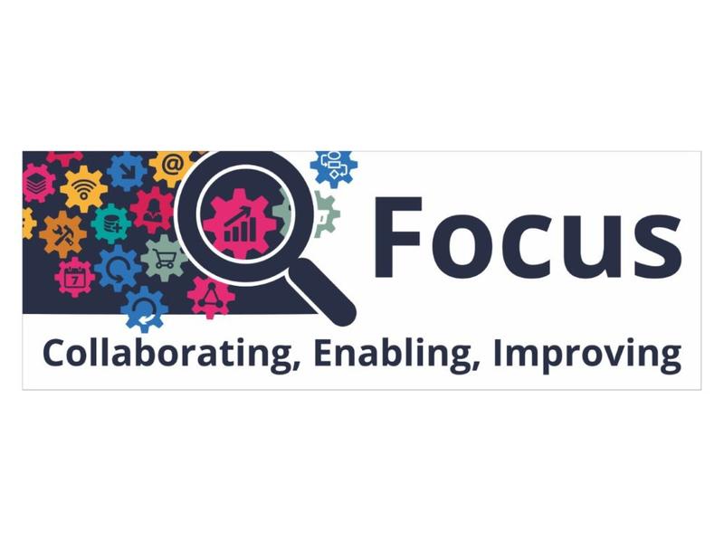 Focus logo large 1280 x 451 px Focus Logo - Navy and white logo with multi coloured cogs - each with a different symbol on it - and a large magnifying glass