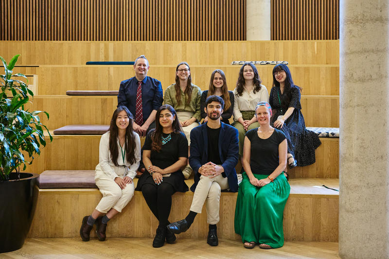 Some of the LPL Fellows smile for the camera, seated on steps