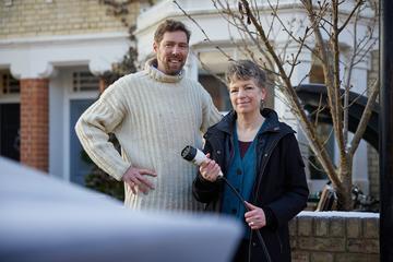 Dr Phil Grünewald and Dr Tina Fawcett hold an electric vehicle charging cable 