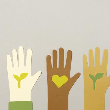 Three paper cut-outs of hands of different skin colour, each holding a paper cut out of a leaf or a heart
