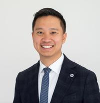 Dr Bo-Jiun Jing Dr Juin has short black hair. He is wearing a white shirt, blue tie and navy suit jacket.