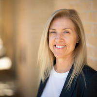 Trudi lang stands against a brick wall