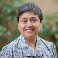 Nandini gooptu stands outside against a leafy bush