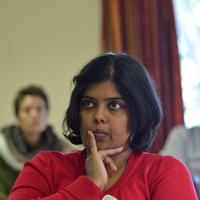 Usha kanagaratnam is photographed listening in a meeting, with her hand on her chin