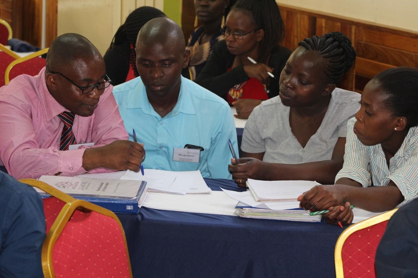 Four school leaders in discussion, seated around a table