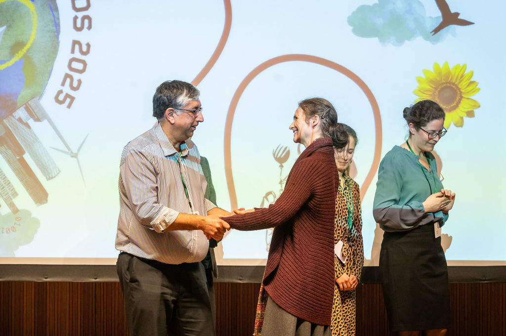 Prof Chas Bountra shakes hands with Sabina Alkire of OPHI 