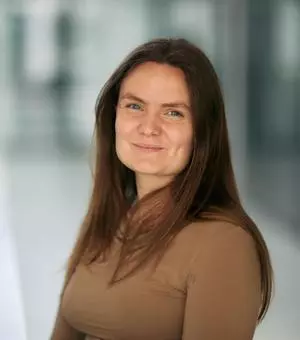 Woman with long dark hair smiles to camera