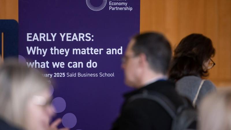 An event banner with the words "Early Years: Why they matter and what we can do" amongst a busy room of delegates