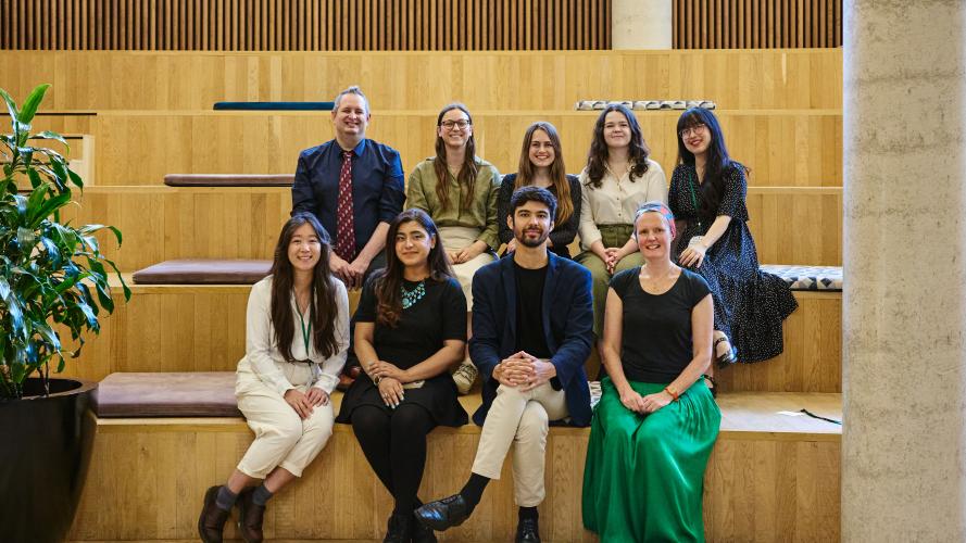 Some of the LPL Fellows smile for the camera, seated on steps