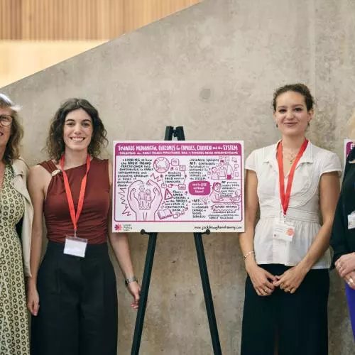 Four women of different ages stand on the sides of a poster created for the event. The poster itself is not very legible