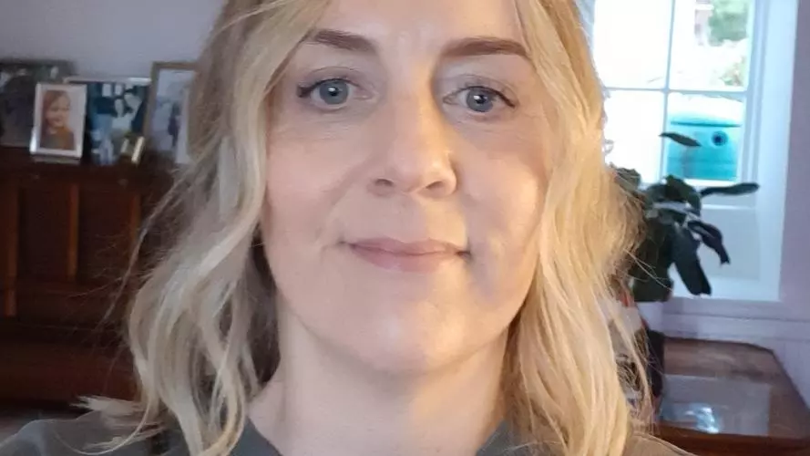 Tessa has long blonde hair and is smiling at the camera