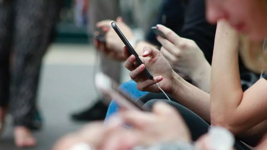 A group of people scrolling through their devices