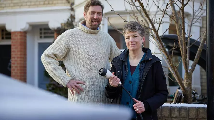 Dr Phil Grünewald and Dr Tina Fawcett hold an electric vehicle charging cable 