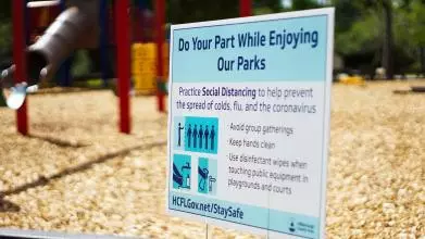Government advice poster in front of an empty children's playground_jordan hopkins xxgpojrufbc unsplash