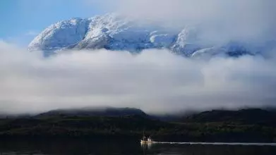 people in a boat on a river in Chile with mountains in the background