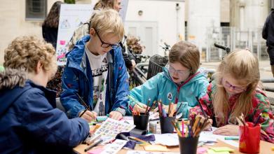 Four children participate in an activity using colouring pencils