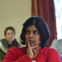 Usha kanagaratnam is photographed listening in a meeting, with her hand on her chin