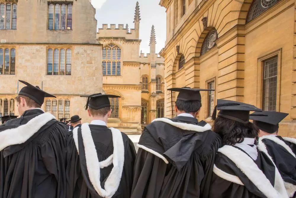 Students wearing gowns and mortar boards outside the Sheldonian