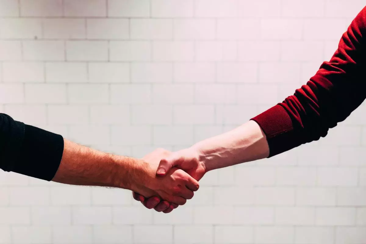 Two people shake hands
